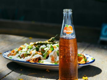 a-bottle-of-soda-sitting-on-top-of-a-table-next-to-a-plate-of-food.jpg a bottle of soda sitting on top of a table next to a plate of food